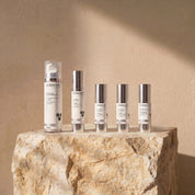 Authentic Ageing Collection lifestyle image showing Cream Cleanser, Hydra Cream, Vitamin A 1% + B Serum, Triple Vitamin C Serum and Exfoliant Fusion Serum by Science Skincare, styled on a raw stone plinth with natural shadow play
