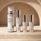 Breakout Collection lifestyle image showing Carbon Cleanser, Hydra Lotion, Vitamin A 0.5% + B3 Serum and Clear + Calm Serum by Science Skincare, styled on a stone ledge against a warm sandstone arch