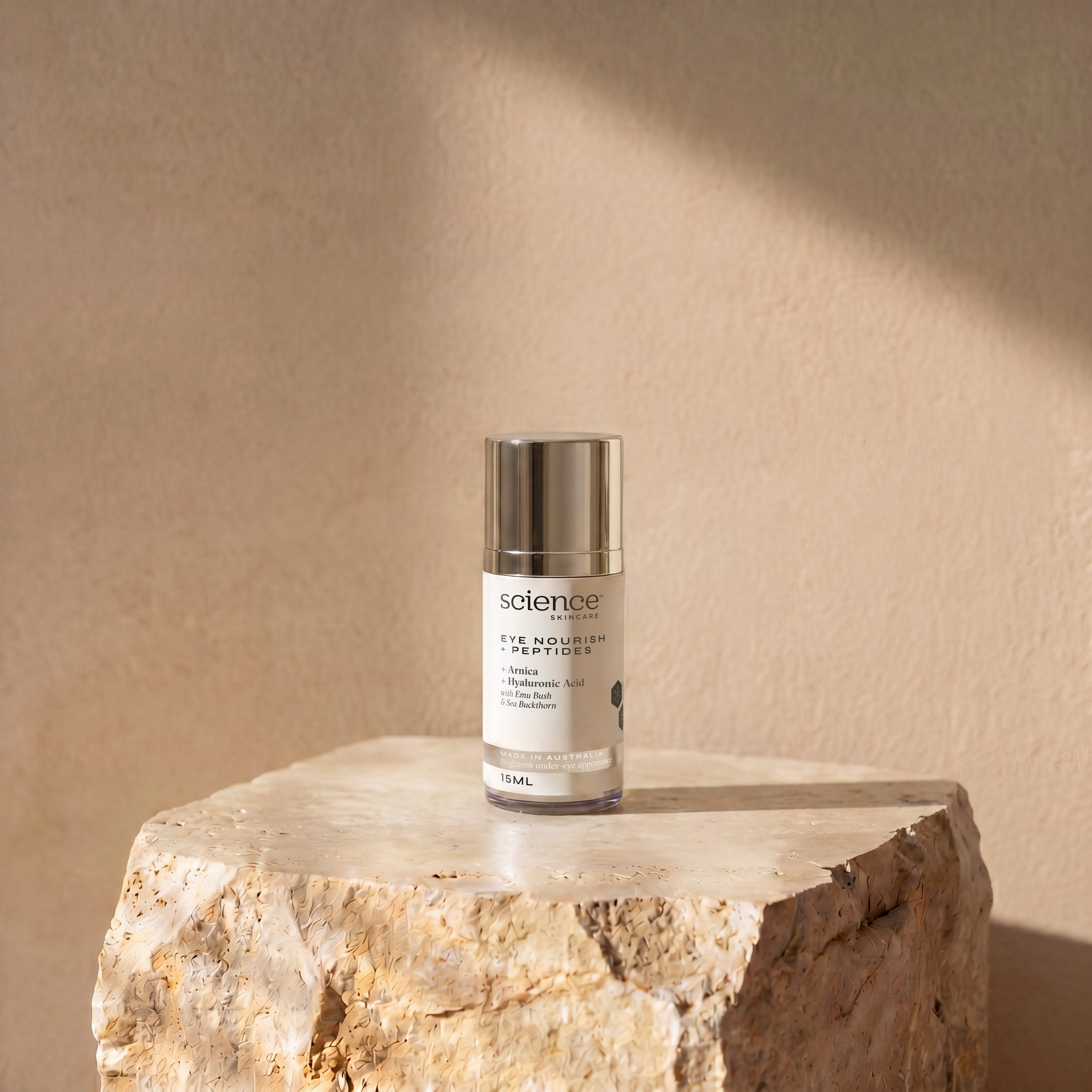 Eye Nourish + Peptides lifestyle image showing the 15ml Science Skincare eye treatment with arnica, hyaluronic acid, emu bush and sea buckthorn, styled on a raw stone plinth with natural shadow play

