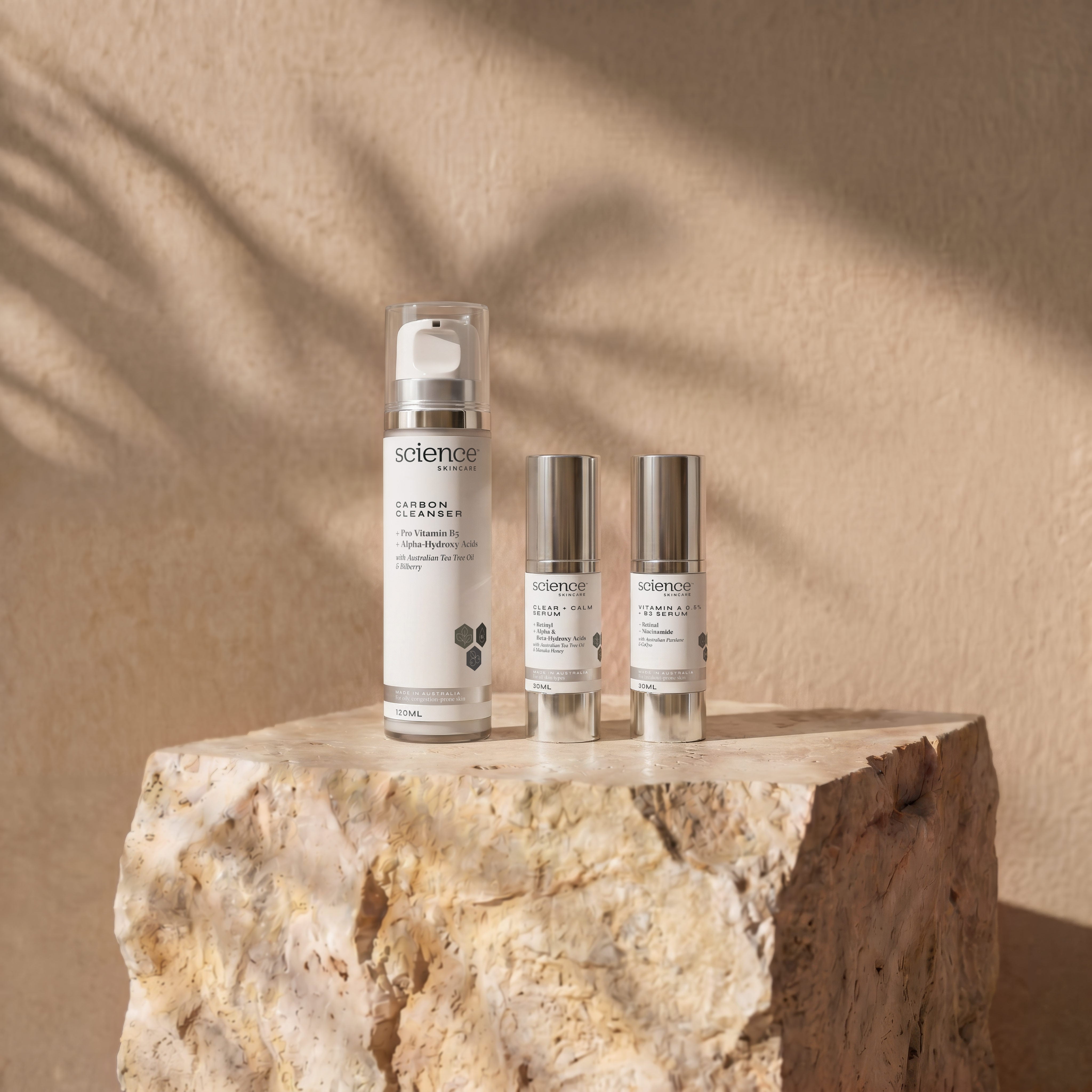 Mankind Collection lifestyle image showing Carbon Cleanser, Clear + Calm Serum and Vitamin A 0.5% + B3 Serum by Science Skincare, styled on a raw stone plinth with natural shadow play