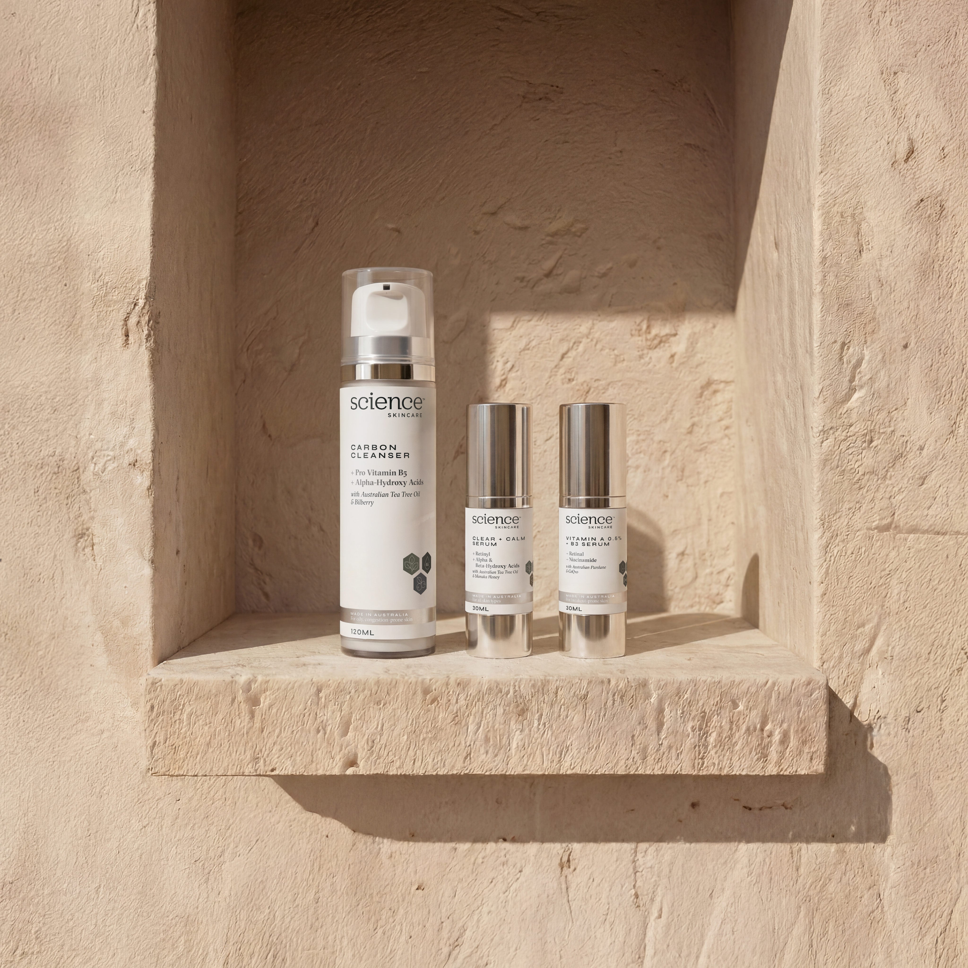 Mankind Collection lifestyle image showing Carbon Cleanser, Clear + Calm Serum and Vitamin A 0.5% + B3 Serum by Science Skincare, styled in a warm stone wall niche in natural light