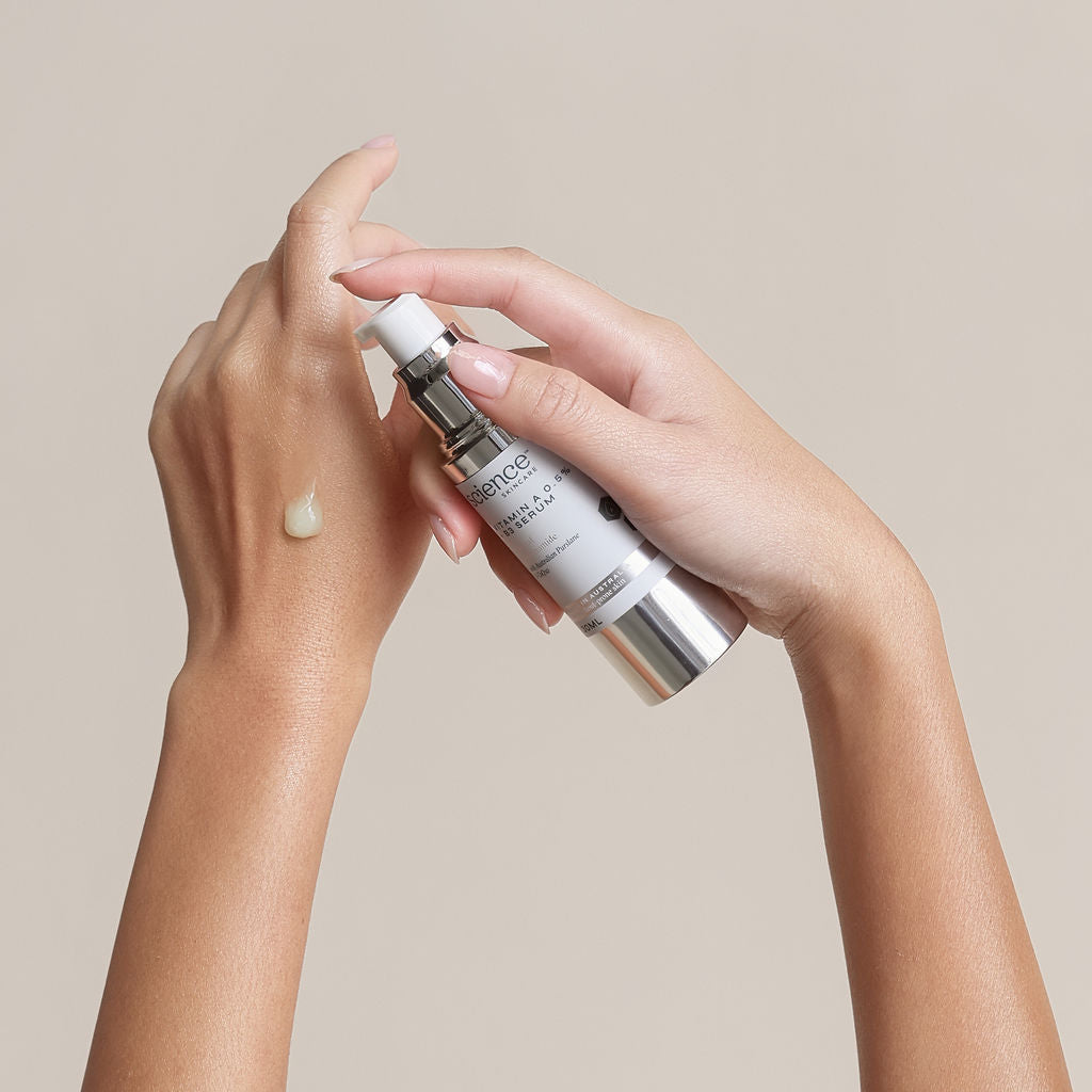 Hand holding a skincare product with a beige background

