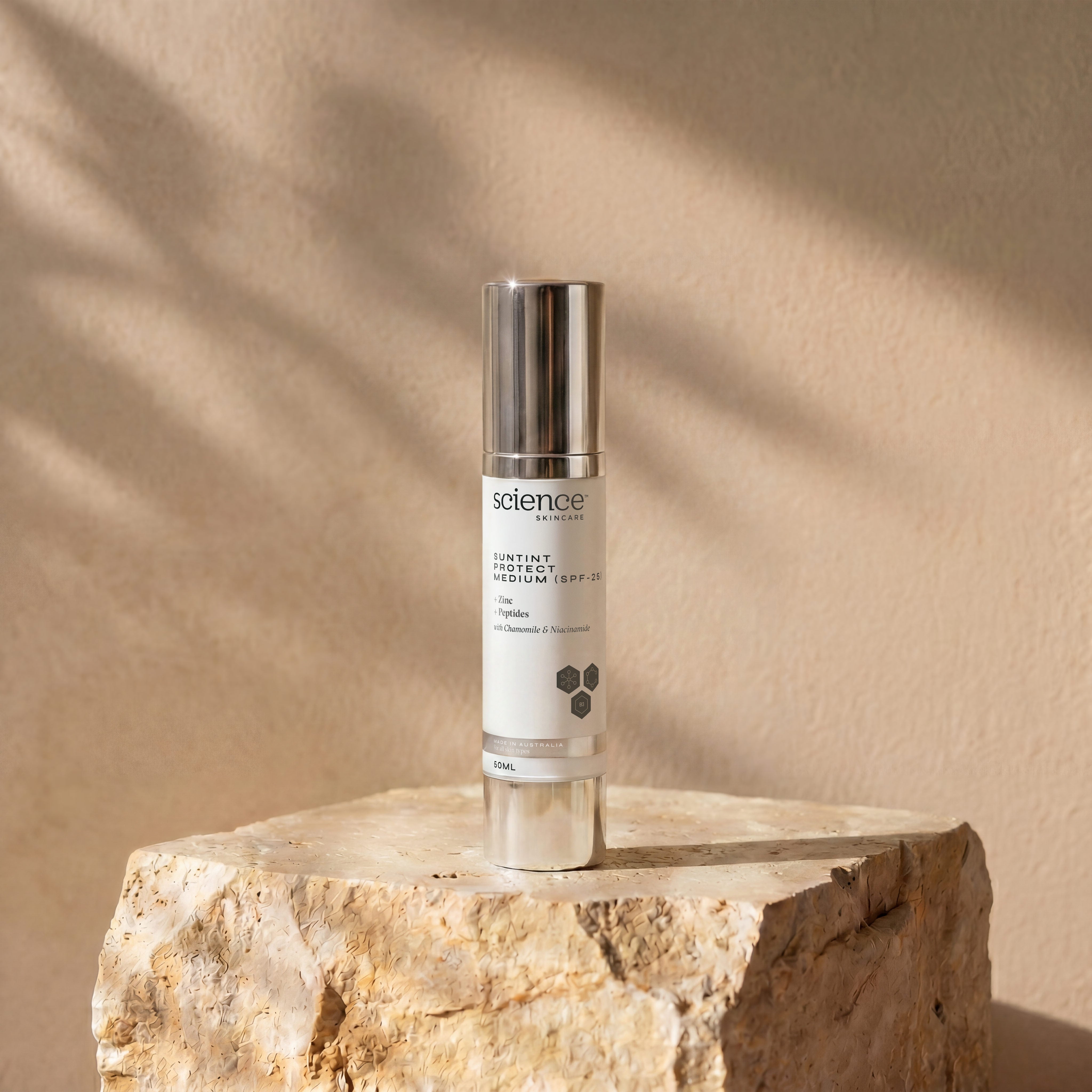 Suntint Protect Medium SPF-25 lifestyle image showing the 50ml Science Skincare tinted sunscreen styled on a raw stone plinth with natural shadow play
