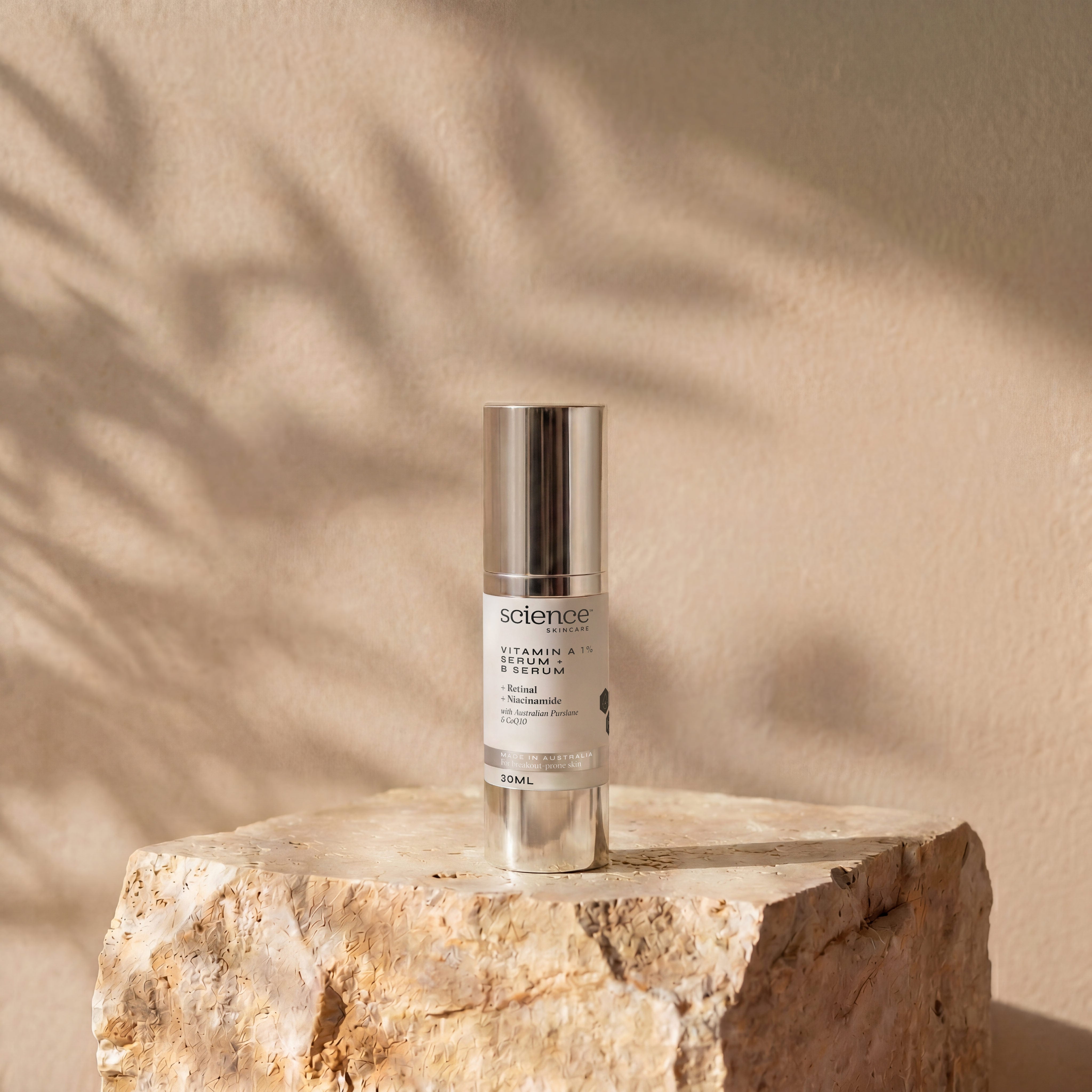 Vitamin A 1% Serum + B Serum lifestyle image showing the 30ml Science Skincare serum with retinal, niacinamide, Australian purslane and CoQ10, styled on a raw stone plinth with natural palm shadow play
